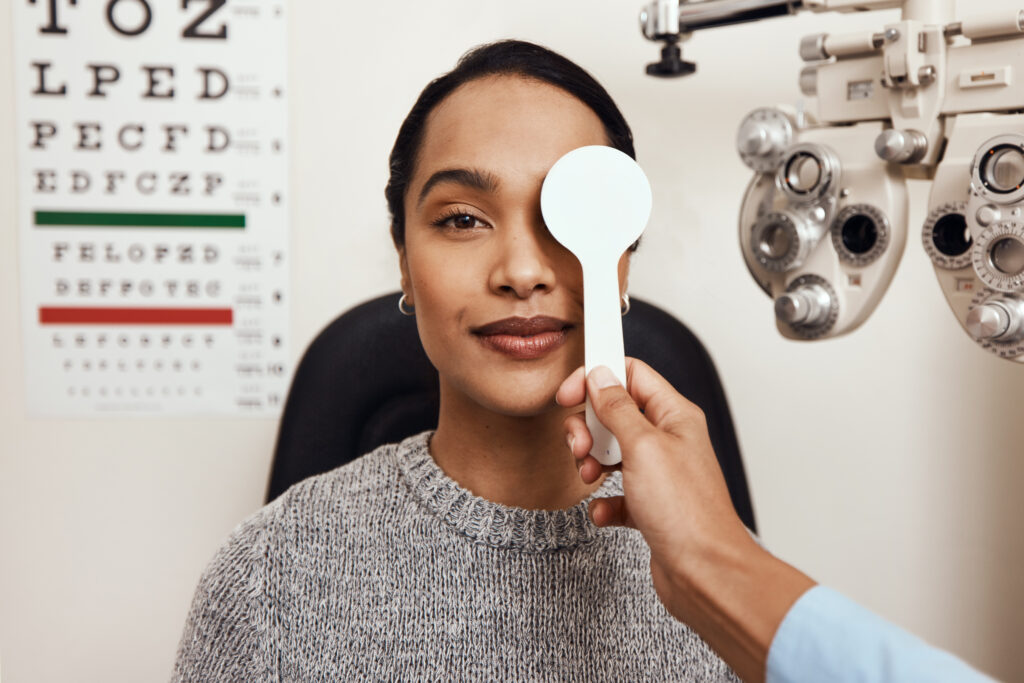 Shot of an optometrist covering her patients eyes with an occluder during an eye exam